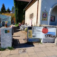 Seiteneingang mit Kaffee und Kuchen-Schild am Scala